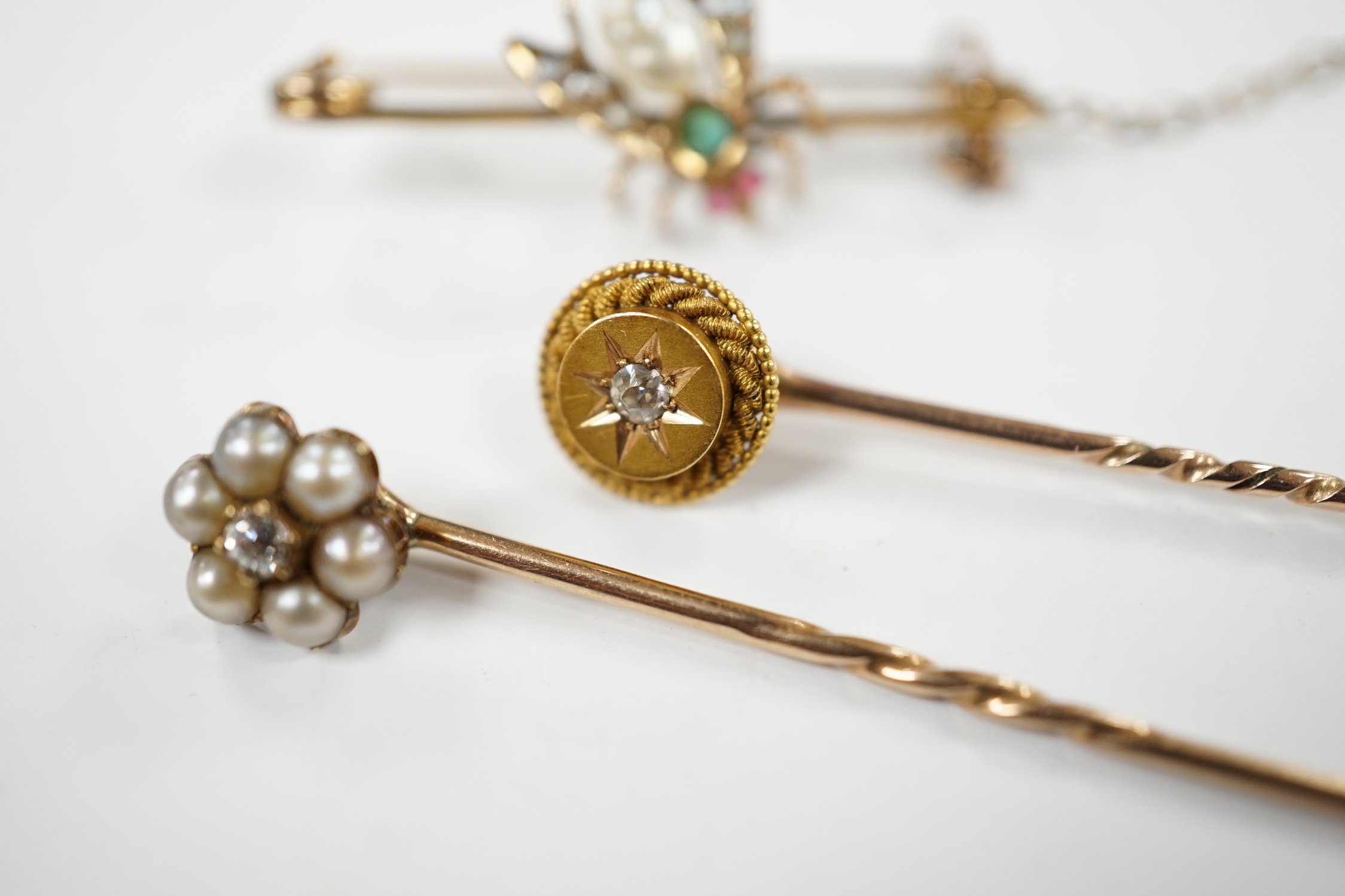 An early 20th century 9ct and gem set bug brooch, 34mm and two yellow metal stick pins, diamond and diamond and seed pearl set.